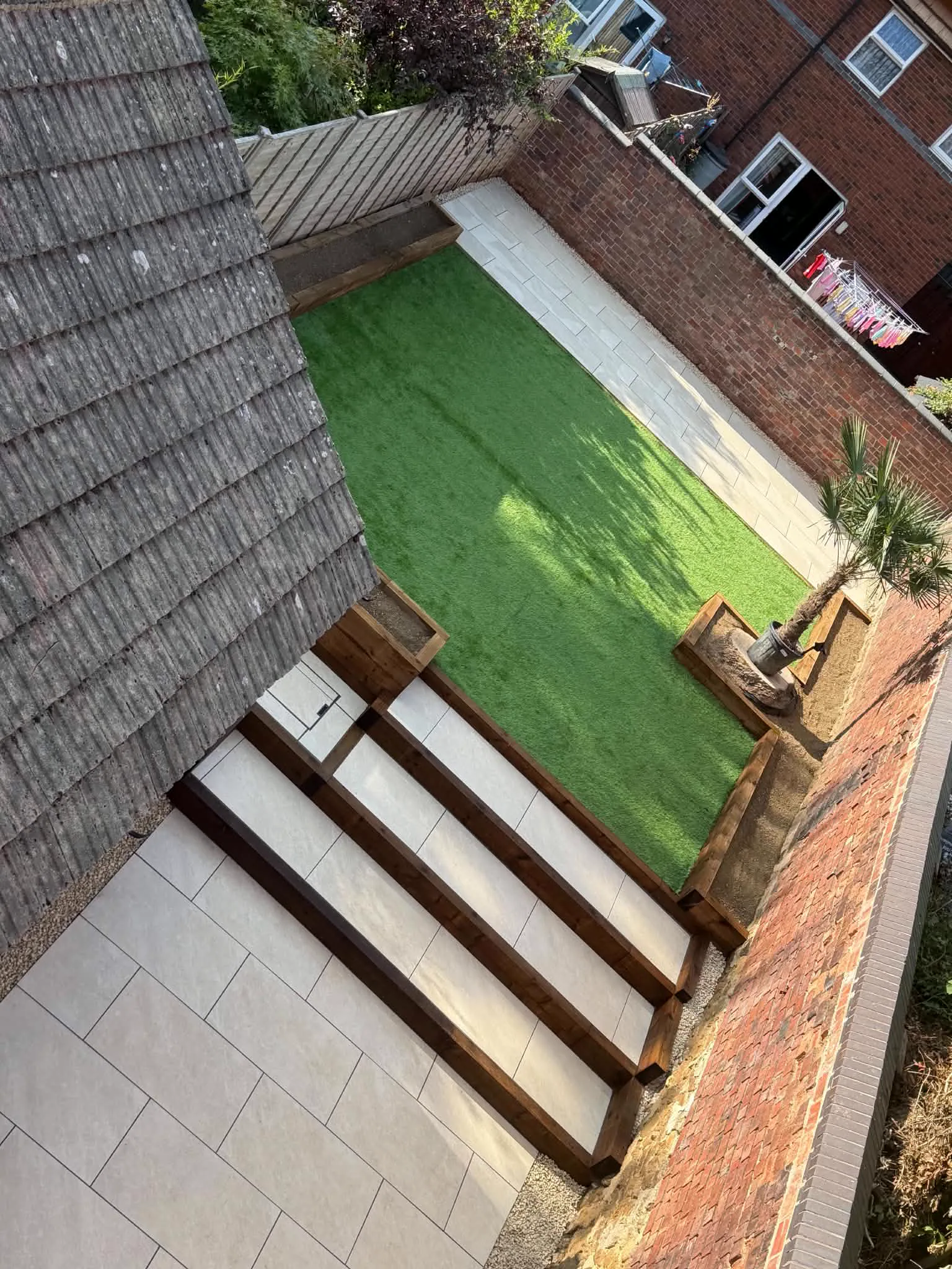 The same garden after new paving, steps and artificial lawn installation